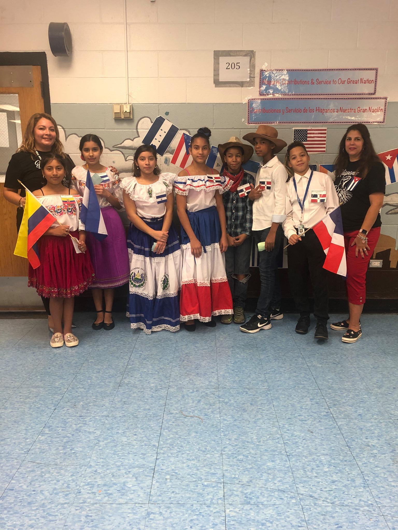 Mrs. Ramirez and Mrs. Camacho with several students wearing their folk attire